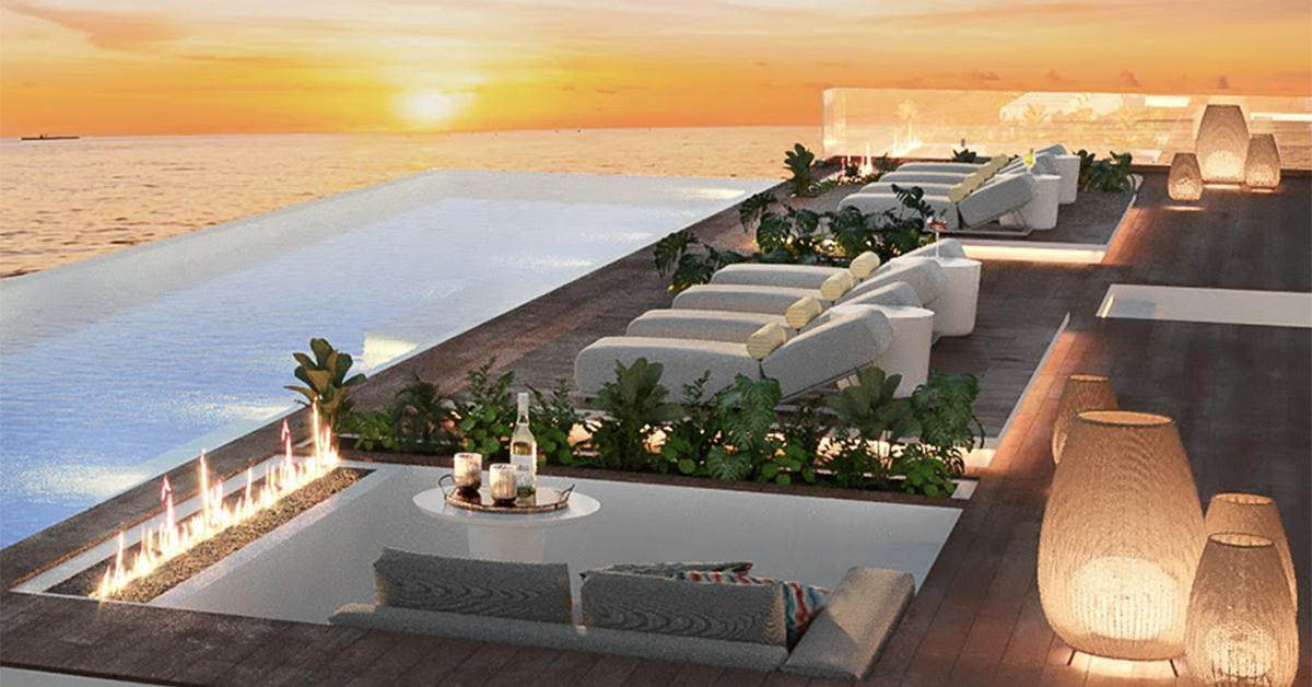 Rooftop infinity pool and loungers at sunset
